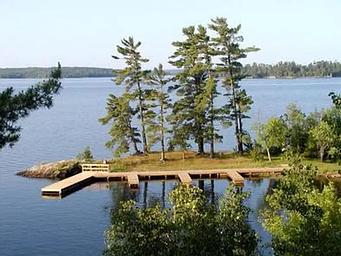 Aerial view of the Kabetogama Lake Group campsite with three large docks overlooking a large, scenic lake.