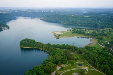 High-resolution aerial view of Lake Cumberland shoreline and surrounding green space/parkland — useful as a scenic site overview and local setting image used on the property's 'Things to Do' page.