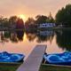 Evening view across the central pond with dock and paddleboats, RVs and cabins visible around the shoreline — highlights the park’s pond recreation area referenced on the homepage.