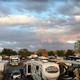 Wide view of the RV parking area showing many full‑size RVs and the park layout with trees and surrounding landscape — useful overview of campsite density (from site homepage gallery).