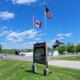 Wide entrance/grounds view showing the campground sign, buildings, paved road and RV sites — good overall overview (image from the Rates/home gallery on the property website).