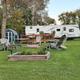 Shows an arranged seasonal site with deck, firepit seating and RV in the background — good detail of typical site amenities (from seasonal sites page).