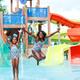 Colorful waterpark/pool splash area with slides and children playing — good overview of the park’s aquatic attractions. Located in the site’s activities/facilities photos.
