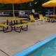 Poolside view showing the campground’s pool deck, umbrellas and nearby RV parking — useful facility shot (listed under campground activities/recreation).