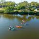 Aerial hero image showing the campground shoreline, water access with kayakers and multiple cabins/RV sites visible — good overall overview of the property (source page background/hero).