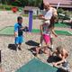 Image of the miniature golf area with children playing — shows an on-site recreational facility (used on Contact/Amenities pages) and helps convey family activities available.