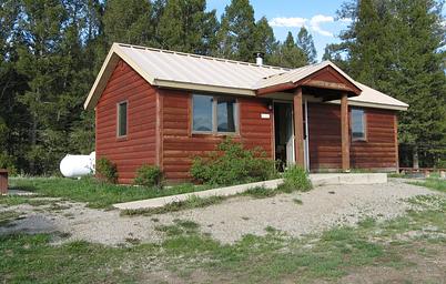 A red wooden cabin with two wings