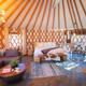 Bright, well-staged interior shot of a yurt main room (bed, seating, dining) — excellent for showcasing the furnished luxury yurt interior; appears on the site’s main yurt listing pages.