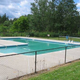 Photograph of the on-site swimming pool, fenced and with surrounding grounds — documents recreational facility (homepage image).