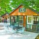 Shows rustic cabins with outdoor patio furniture set on concrete pads surrounded by trees — useful cabin accommodation shot from the campground 'ways to stay' images.