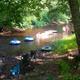 River tubing and shoreline scene showing floating tubes and people at the water’s edge — illustrates guest activities and the campground’s river recreation (floating-down-the-river image).