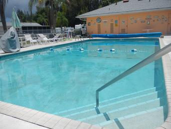 Clear photograph of the resort swimming pool with surrounding seating and a pool house in the background — matches the homepage/gallery pool imagery and highlights amenities.