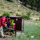 A camper is using a food storage box in Aspenglen Campground