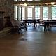 View of the inside of the Clark Lake pavilion with windows, bench, and picnic tables.