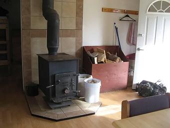 A black iron woodstove at the entrance to a cabin