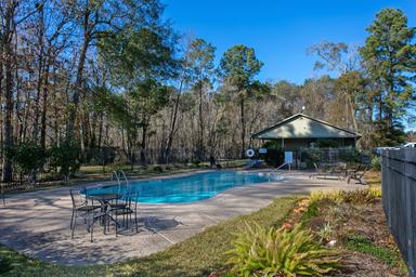 Alternate angle of the same pool with adjacent seating and clubhouse building at the pool — useful to show amenities and grounds from a different viewpoint (from the amenities page/gallery).