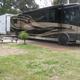Ground-level view of an RV on a site with picnic table and pad — depicts the campground's RV accommodations and site setup.