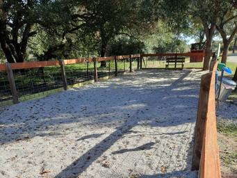 Image of a fenced dog park area with seating and shade — documents pet-friendly amenity and outdoor space on the property (Amenities page).