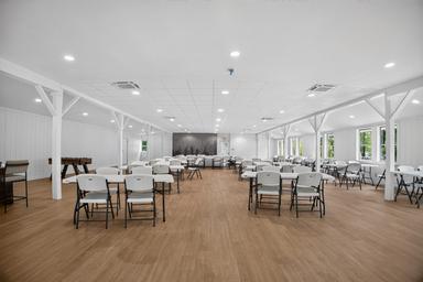 Large multi-use community hall with tables and chairs — shows an on-site event/meeting facility for guests (from the site photo gallery).