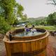 Couple enjoying the wood-fired barrel hot tub at Zen Zion with mountain views