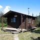 Koknuk cabin with two wood plank trails leading to it 