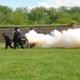 Park volunteers in Civil War Union clothing firing the park's cannon.  The flame and smoke billowing out after the shot.