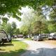 Clear daytime view of RVs, cars and campsite pads along a gravel lane — good depiction of the campground’s RV pitching area (image from the site’s homepage/media gallery).