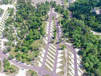 Aerial view focused on the RV pad rows and surrounding trees — useful detailed overview of site arrangement and vegetation; sourced from the site's gallery images.