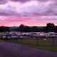 Wide view showing the campground layout with many RVs, fencing and surrounding landscape at sunset — useful aerial/overview from the site’s image slider (homepage slider image).