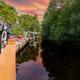 View along a landscaped canal/boardwalk with residential patios visible — shows on-site waterfront/canal setting and appears in the property’s gallery imagery.
