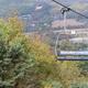 Chairlift close-up with valley and resort access roads visible below — highlights lift infrastructure and scenic views of the property. Shown on the resort homepage.