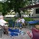 Senior campers using chair assistance and visiting at campsite.