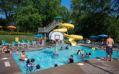 Main swimming pool with a large water slide and lounge chairs — shows the pool amenity and guest use (homepage image of pool area).