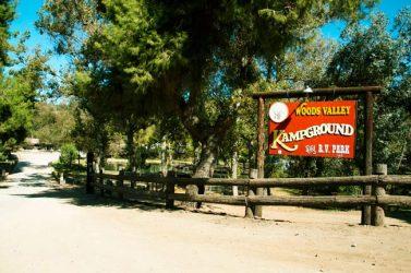 Entrance sign reading 'Woods Valley Kampground' with fencing and roadway — good exterior identification shot from the campground gallery (page: https://www.woodsvalley.com/our-campgound/).
