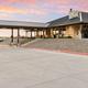 Exterior panorama of the clubhouse/building and adjacent outdoor areas at sunset — highlights the main clubhouse and gathering spaces used by guests (gallery hero/images show clubhouse).