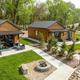 Raised-angle shot of multiple cabin units with patios and fire rings along the shoreline — useful overview of cabin accommodations and landscaping near the lake.