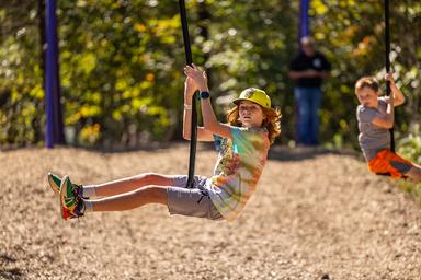 Kids swinging outdoors at Asheboro Jellystone Park