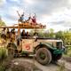 Historic-style safari tour vehicle with guests on the property and park landscape visible — represents on-site tours and the guest experience (used as background on site home page).