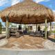 Photo of a thatched-roof palapa seating area near the clubhouse and pool—shows outdoor shaded gathering space featured in the property gallery.