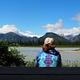 Person from behind looking at view from Shakes Slough 2 Cabin entrance showing mountains and water