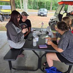 Covered picnic pavilion with picnic tables and nearby utility vehicles — shows social/gathering facility and site infrastructure for guests (Gallery page).