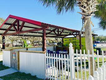 Covered outdoor pavilion/Tiki-bar area with fencing and seating — shows a social/amenity space guests can use (matches images of on-site clubhouse/bar area).
