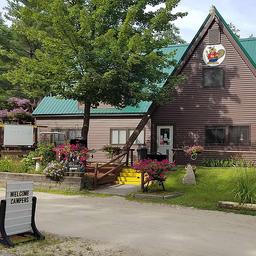 Front exterior of the campground office/building with signage, landscaping and ‘Welcome Campers’ board — good for showing on-site facilities and entrance (photogallery image).