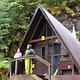 Two people by railing of entrance to Mount Flemer Cabin with trees in background
