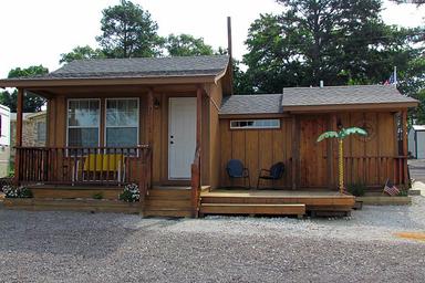 Front-facing cabin photo showing a typical cottage unit and porch — useful to illustrate cabin lodging available on-site (image appears in property photos).
