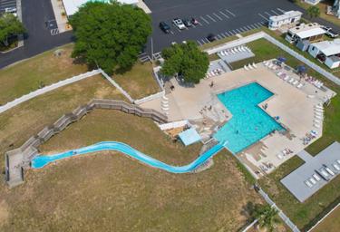 Aerial view of the pool area with a water slide and surrounding deck/chairs — shows a main on-site recreational facility for guests (appears on the resort photo gallery).