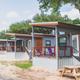 Row of exterior tiny cabins along a paved path — clear overview of cabin accommodations and layout, from the property's gallery page.