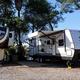 Clear photo of RV spaces with multiple rigs parked, showing typical paved/gravel pads and site setup — useful for prospective RV guests.