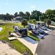 Drone image of RV pads and adjacent pond with several rigs visible — clear view of typical RV sites and onsite water features; originates from the 'plan your stay' page.