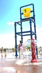 Splash pad play feature with water bucket and active fountain area — good depiction of family water amenities (matches Events/Pool imagery on the website).
